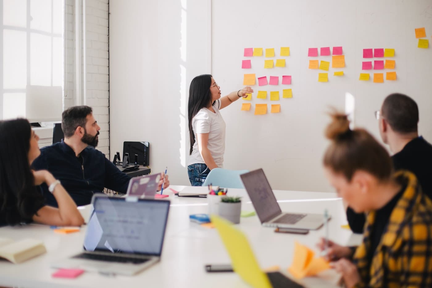 A team collaborating and communicating around a table in a bright office